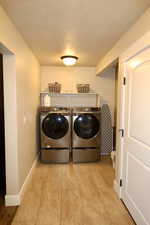 Washroom featuring washer and dryer and a textured ceiling