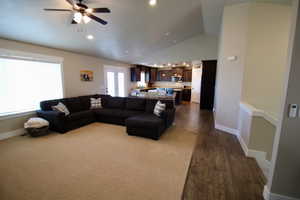 Living room featuring dark hardwood / wood-style floors, ceiling fan, and high vaulted ceiling