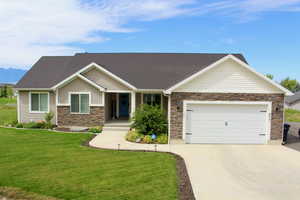 View of front of property featuring a front yard and a garage