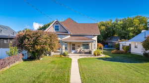 View of front facade featuring a front lawn and a porch