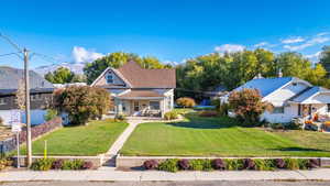 View of front of house with covered porch and a front yard