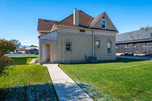 Rear view of property with a lawn