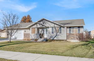 View of front facade with a front lawn and a garage