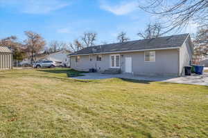 Rear view of property with a yard and a patio area