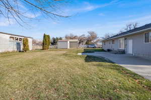 View of d backyard with large concrete patio and shed