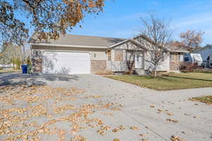 View of front of property with a front yard and a garage along with RV parking