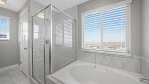 Bathroom featuring shower with separate bathtub and a wealth of natural light