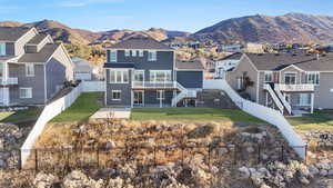 Rear view of property featuring a lawn, a mountain view, cooling unit, and a patio