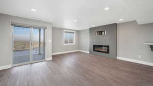 Unfurnished living room with a fireplace, a wealth of natural light, and hardwood / wood-style floors