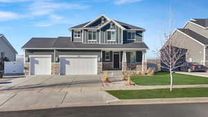 Craftsman house with a porch, a garage, and a front lawn