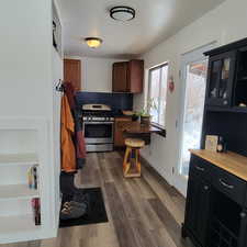 Kitchen with gas stove, dark hardwood / wood-style flooring, and backsplash