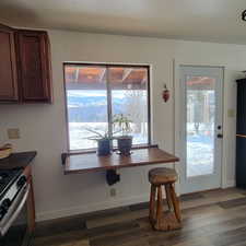 Dining space with plenty of natural light and dark wood-type flooring