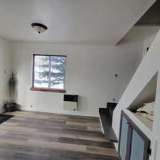 Interior space featuring heating unit and hardwood / wood-style floors