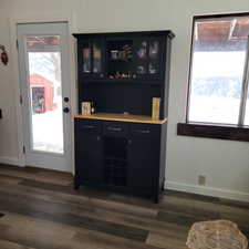 Bar with a wealth of natural light and dark hardwood / wood-style flooring