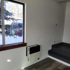 Details featuring heating unit and hardwood / wood-style flooring