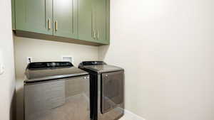 Main floor Laundry room with washer and dryer and cabinets