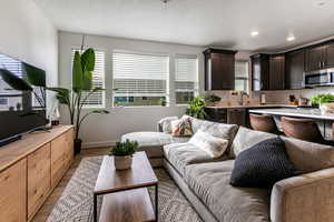 Living room featuring a textured ceiling, light wood-type flooring, and sink