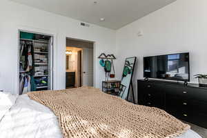 Carpeted bedroom featuring connected bathroom and a closet