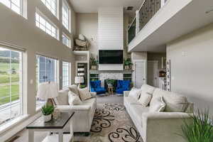 Carpeted living room featuring a tile fireplace and a high ceiling