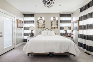 Carpeted bedroom with a chandelier