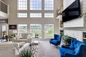 Living room featuring a fireplace, carpet, and a high ceiling