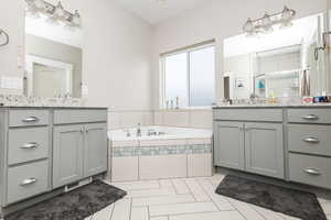 Bathroom with tile patterned flooring, vanity, and shower with separate bathtub