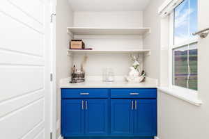 Bar featuring a textured ceiling, plenty of natural light, and blue cabinetry