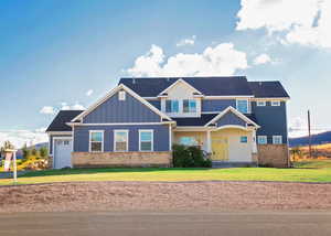 Craftsman house featuring a front lawn and a garage