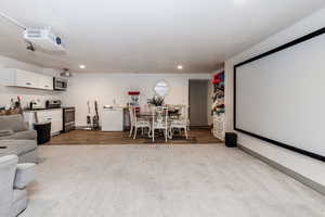 Cinema room with light wood-type flooring and sink