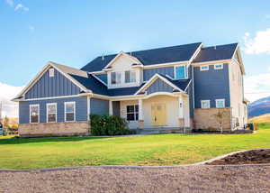 Craftsman-style house with central air condition unit and a front yard