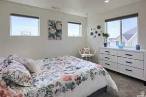 Bedroom with dark colored carpet and multiple windows with amazing views