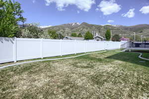 View of yard with a deck with mountain view and fully-fenced yard perfect for fury friends.