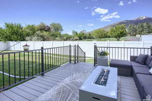 Deck with a mountain view, a yard, and an outdoor living space