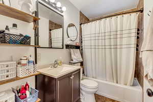 Full bathroom featuring shower / tub combo with curtain, vanity, and toilet