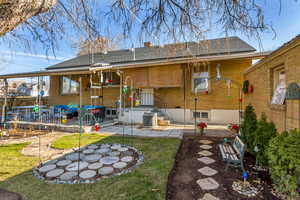 Rear view of house with a yard, an outdoor fire pit, central AC unit, and a patio area