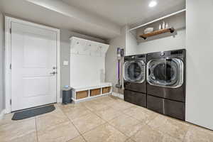 Laundry area with washer and clothes dryer and light tile patterned floors