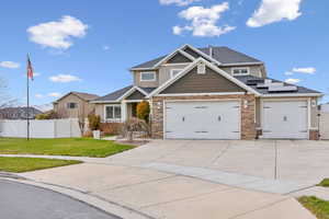 Craftsman house with solar panels, a garage, and a front yard