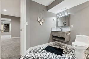 Bathroom featuring decorative backsplash, vanity, and toilet