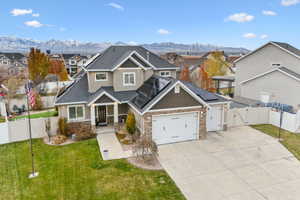 View of front of house featuring a mountain view, solar panels, a garage, and a front yard