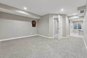 Basement featuring light carpet