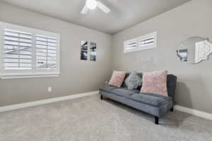 Sitting room with ceiling fan and light carpet