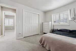 Carpeted bedroom featuring a closet