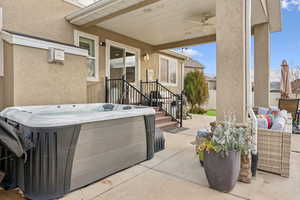 View of patio / terrace with an outdoor living space, a hot tub, and ceiling fan