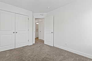 Unfurnished bedroom featuring carpet and a closet