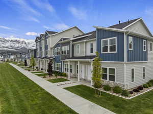 View of front of property with a mountain view and a front yard