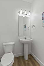 Bathroom with hardwood / wood-style floors and toilet