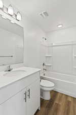 Full bathroom with vanity, shower / bath combination, hardwood / wood-style flooring, and toilet