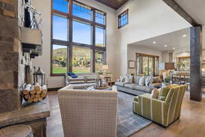 Living room featuring beamed ceiling, a towering ceiling, and wood-type flooring