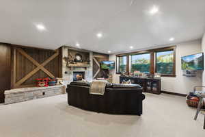 Living room featuring a stone fireplace and light carpet