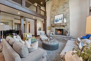 Living room featuring a fireplace, a high ceiling, and wood-type flooring